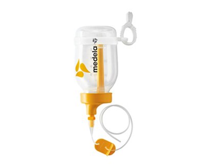Ein zusammengebautes Supplemental Nursing System™ (SNS) mit den dazugehörigen Teilen.